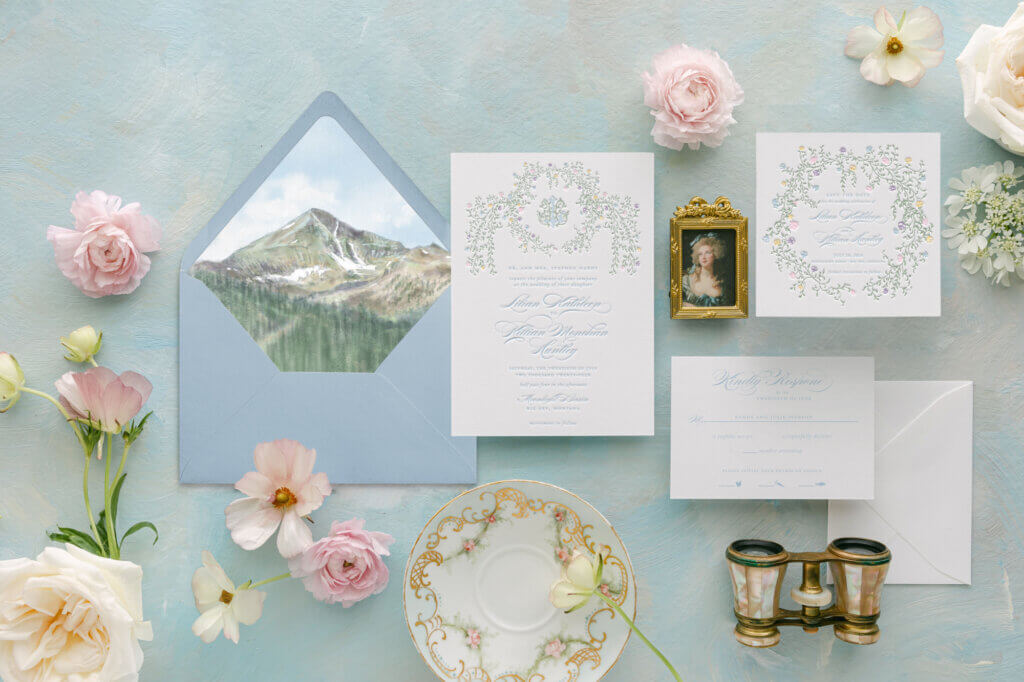 Floral letterpress wedding invitation with a watercolor envelope liner featuring Lone Mountain, for a summer wedding at Moonlight Basin