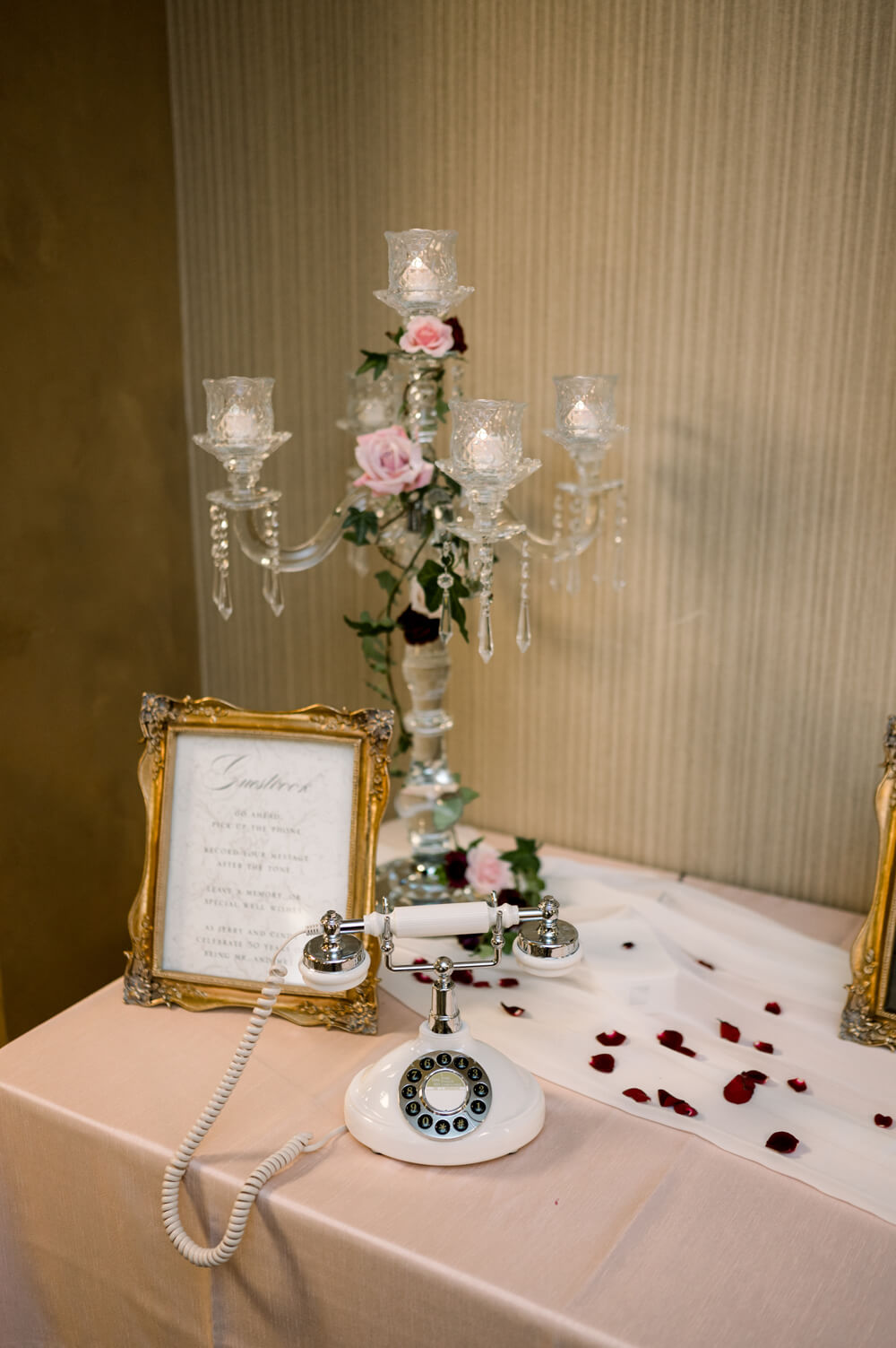 Celebrating 50 Years of Love: Our Parents' Golden Anniversary 16 Victorian-inspired audio guest book station with a vintage rotary phone and candlelit candelabra, designed for guests to leave heartfelt messages at a 50th anniversary party.