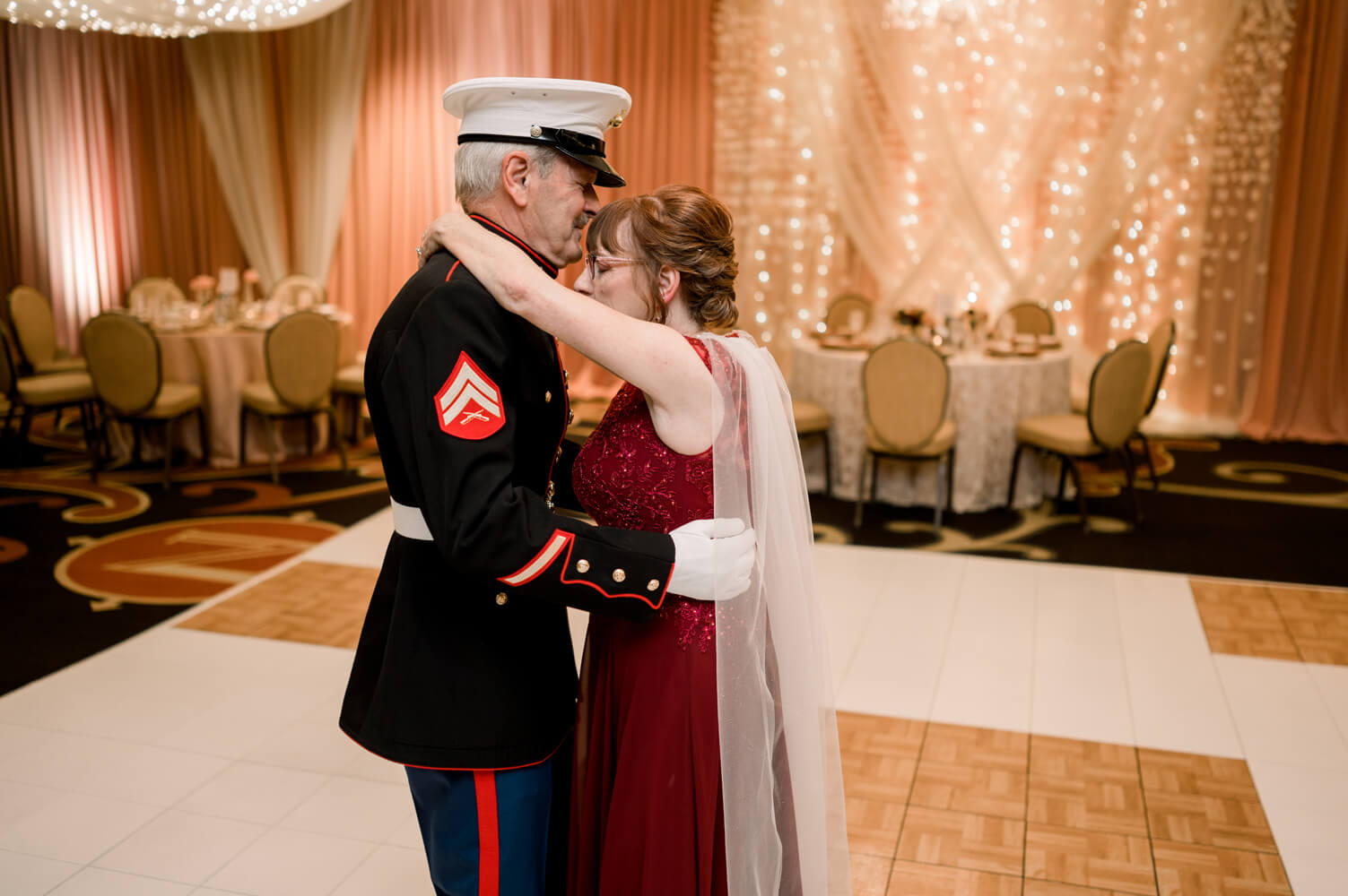 Celebrating 50 Years of Love: Our Parents' Golden Anniversary 33 The couple shares a private first dance on the ballroom dance floor, surrounded by glowing lights.