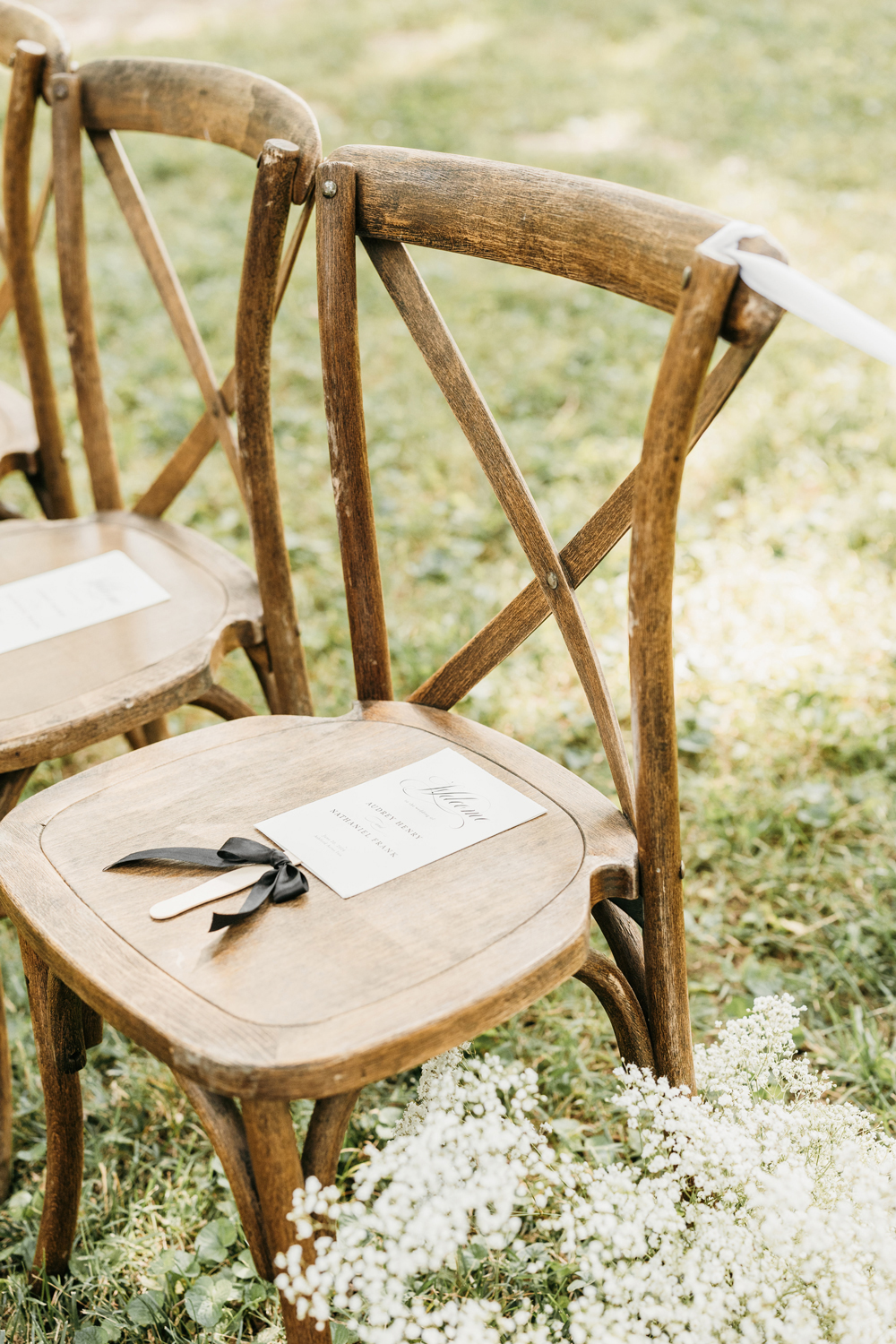 Black and White Wedding Invitations for a Classic Ashford Acres Inn Wedding 14 Rustic wooden ceremony chairs with black and white wedding programs tied in black ribbon, surrounded by baby’s breath floral aisle markers.