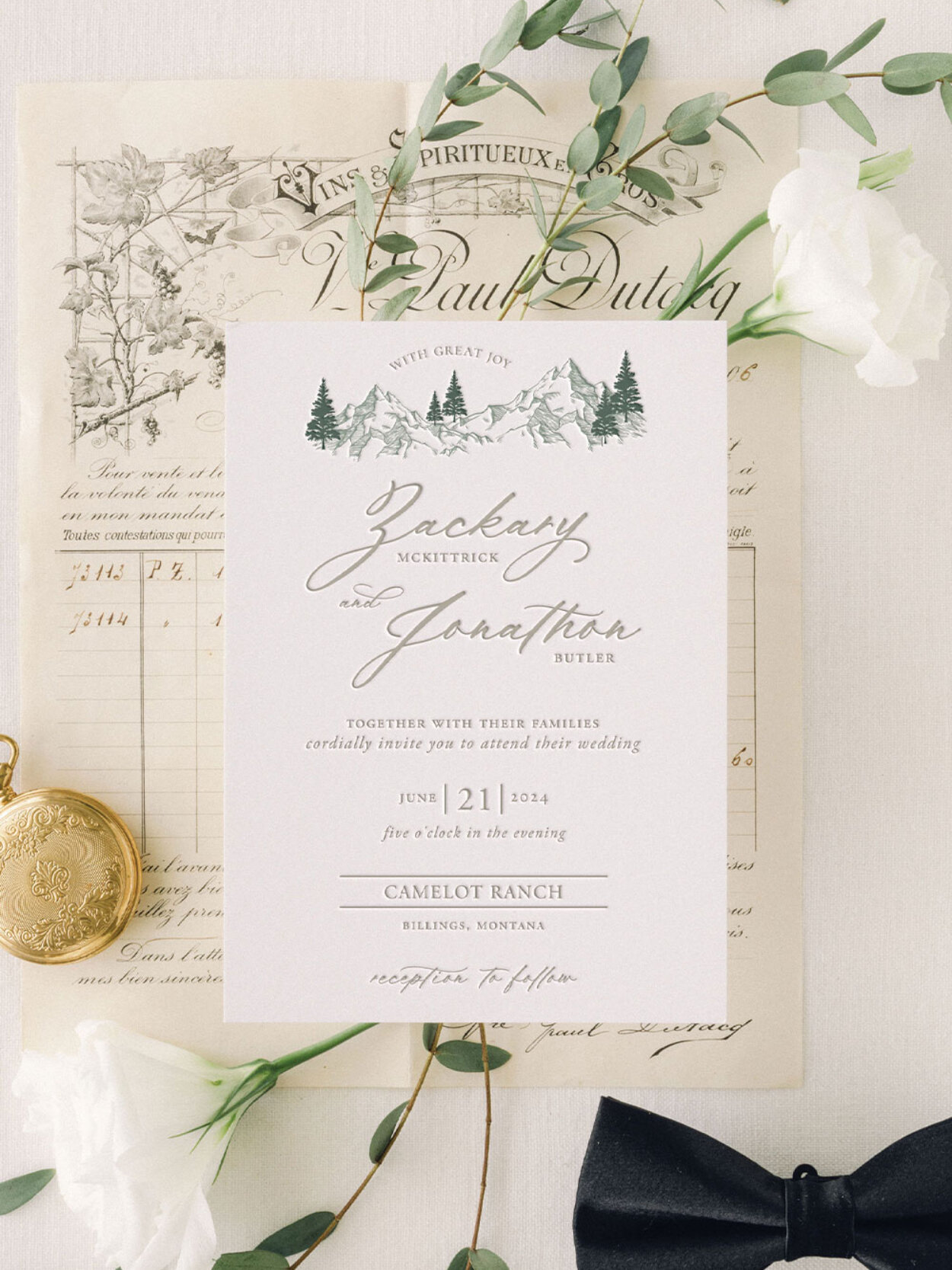 Guide to Luxury Wedding Invitations: What Makes Them Different & Why They Matter 3 Flat lay of a fine art wedding invitation featuring soft typography, mountain illustration, and neutral palette, styled with vintage paper, greenery, wax seal, and silk bow. The composition highlights timeless design and the heirloom quality of luxury wedding invitations.