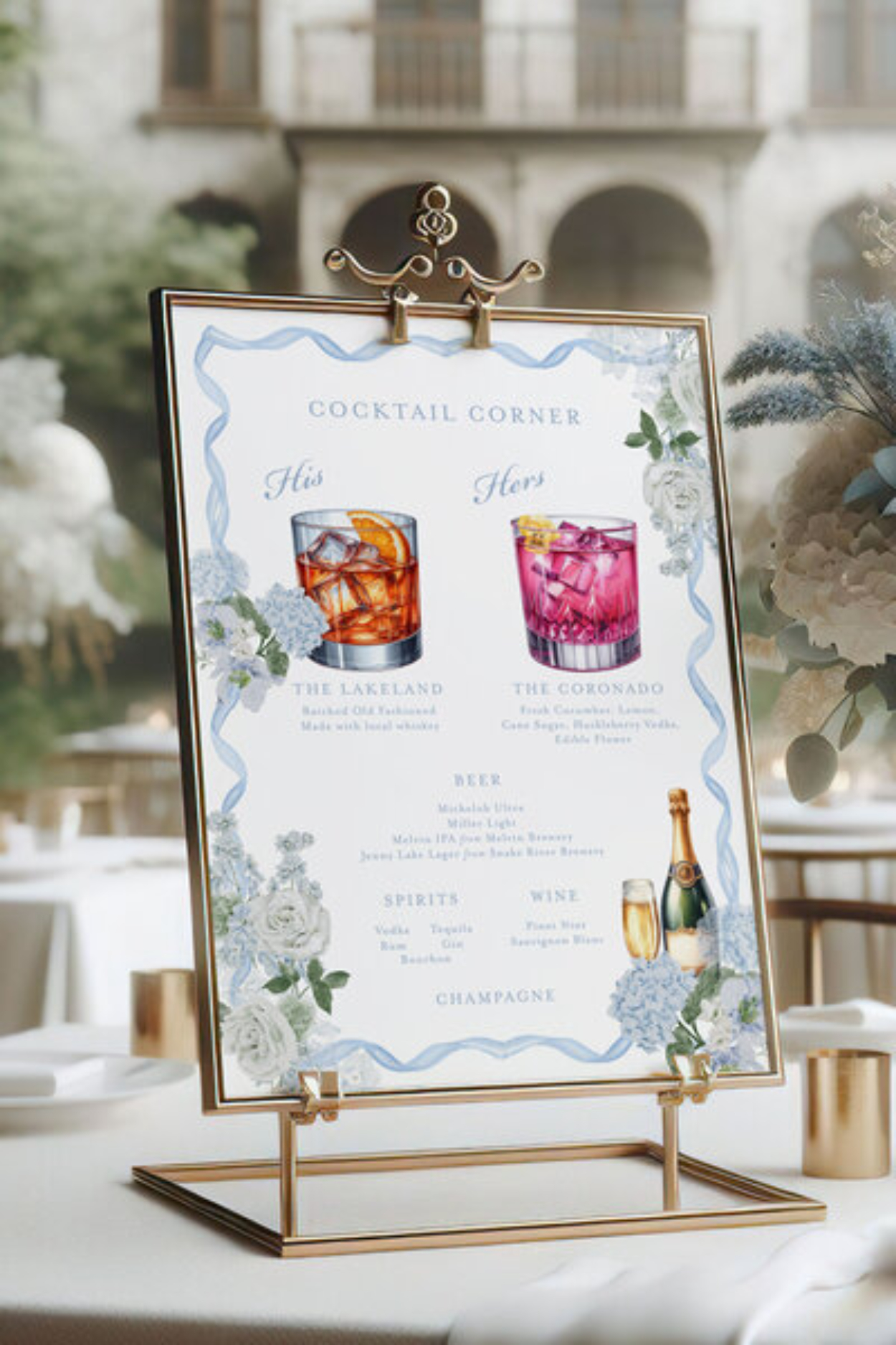 How to Choose a Stationery Designer When “Pretty” Isn’t Enough 3 Elegant cocktail menu sign displayed on a gold stand, featuring illustrated drinks, floral details, and refined typography. Styled on a reception table outdoors, the signage blends beauty and function to guide guests through the wedding experience.