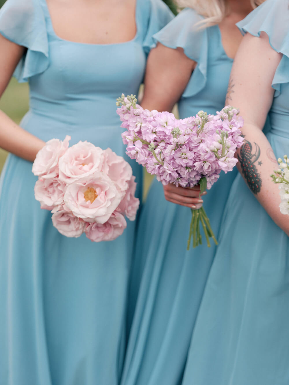 Bridesmaids in pastel blue dresses holding individual floral bouquets at a Moonlight Basin wedding.