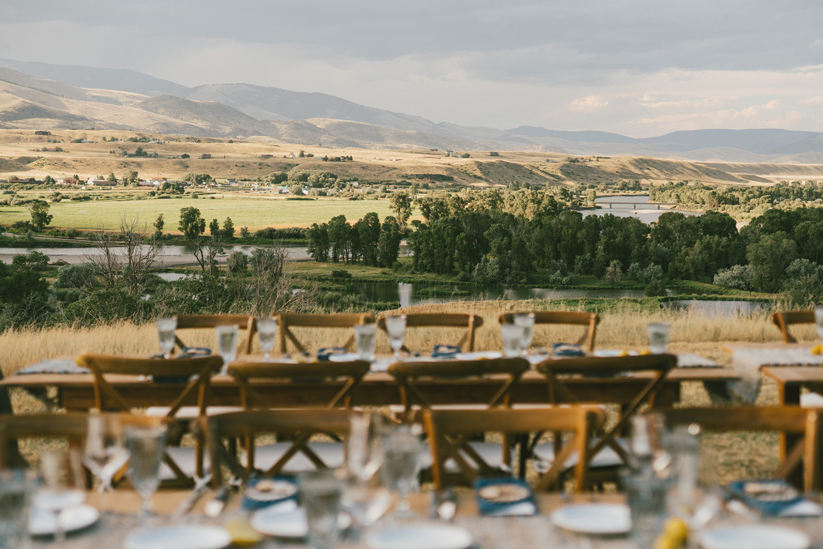 Outdoor reception view overlooking rolling hills, rivers, and mountains during a Sage Lodge, Montana wedding.