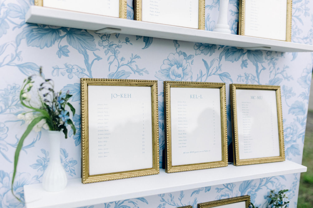 Close-up of gold framed seating assignments for an outdoor wedding. 